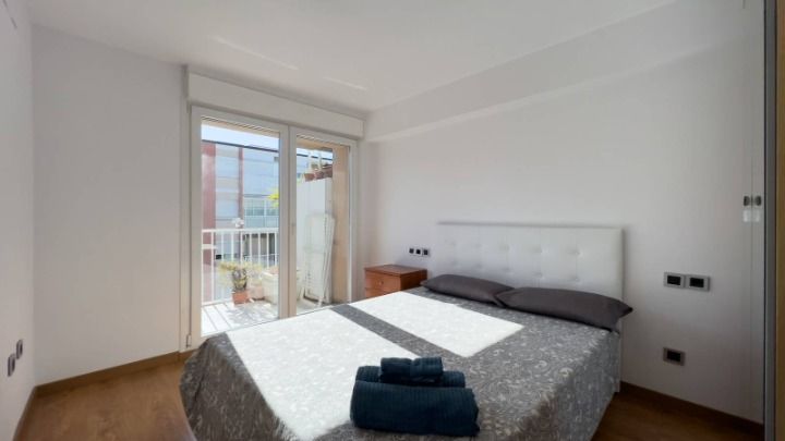 Dormitorio con cama de matrimonio y salida a la terraza